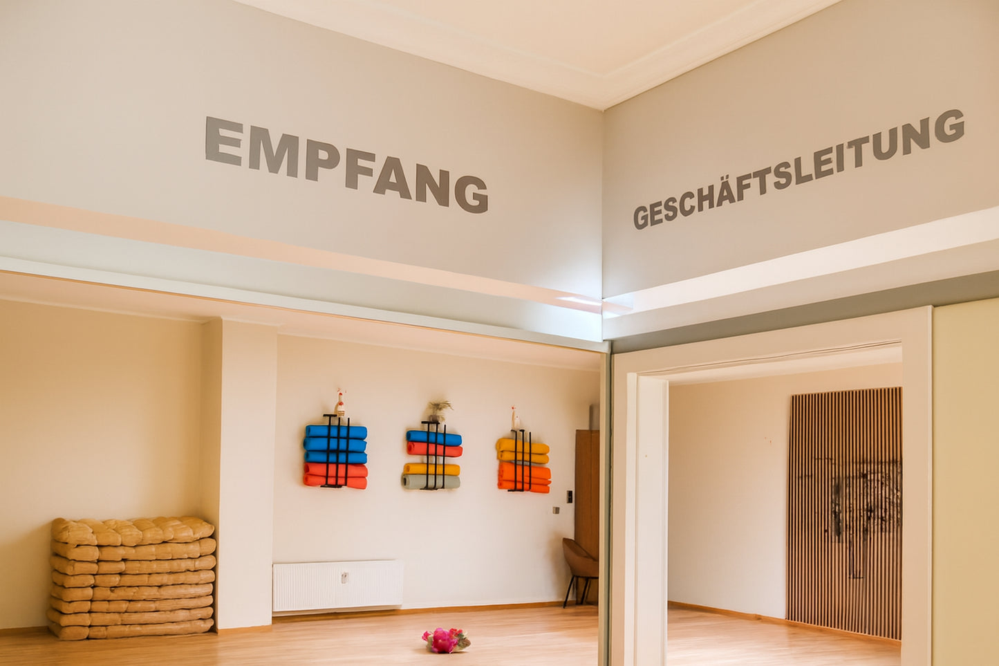 Empfangsbereich mit Yogamatten und Sitzkissen