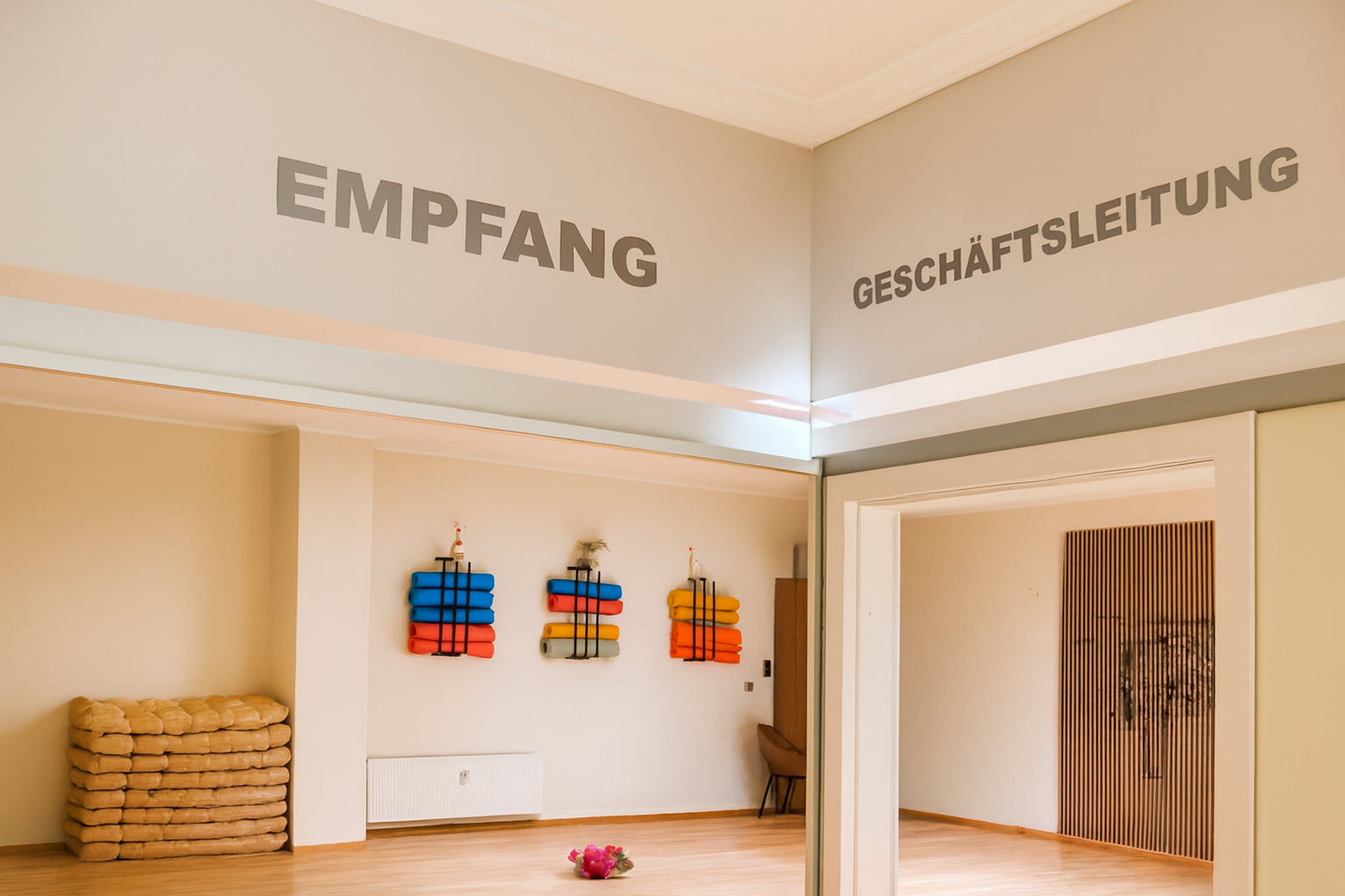 Empfangsbereich mit Yogamatten und Sitzkissen