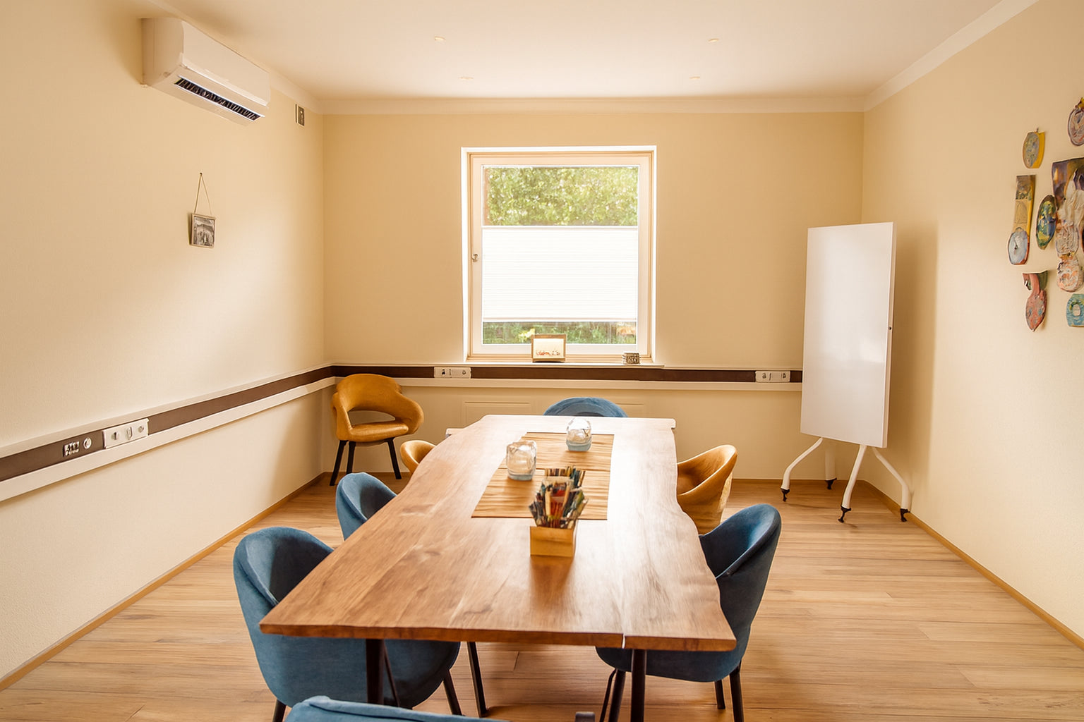 Kleiner Coaching-Raum mit großem Holztisch und Whiteboard