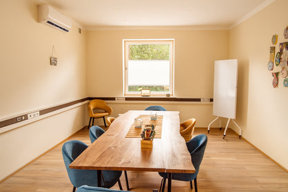 Kleiner Coaching-Raum mit großem Holztisch und Whiteboard